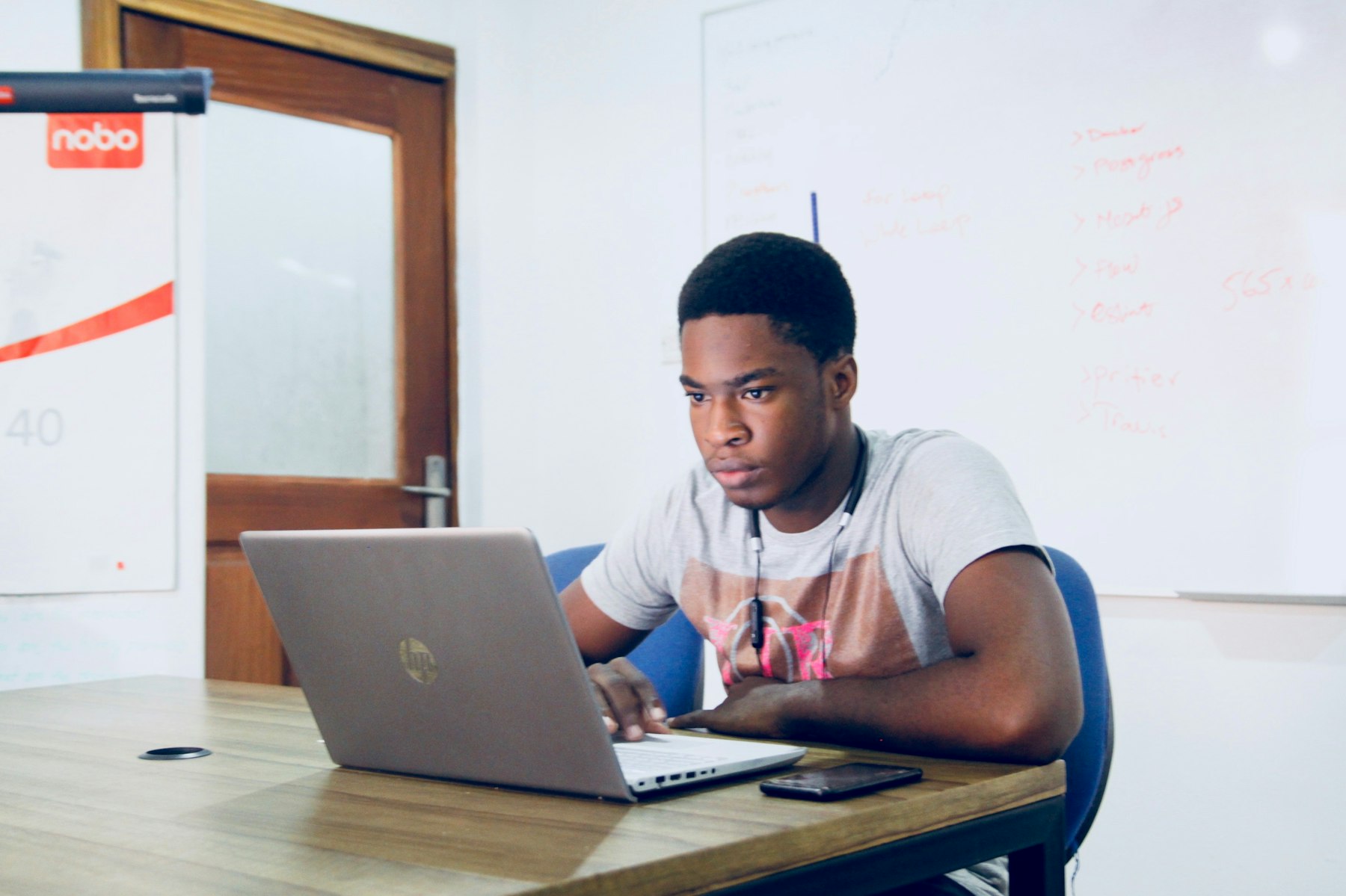 Black Nigerian professional working through a laptop-led implementation workflow in an office.